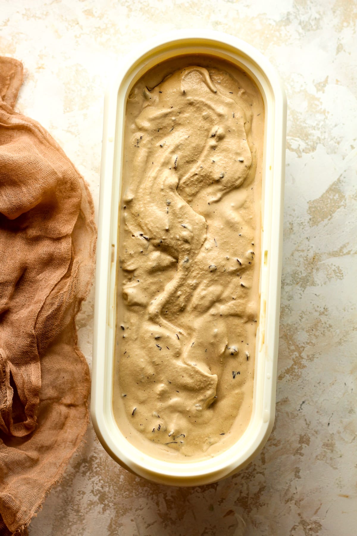 The ice cream in an oblong white container after churning.