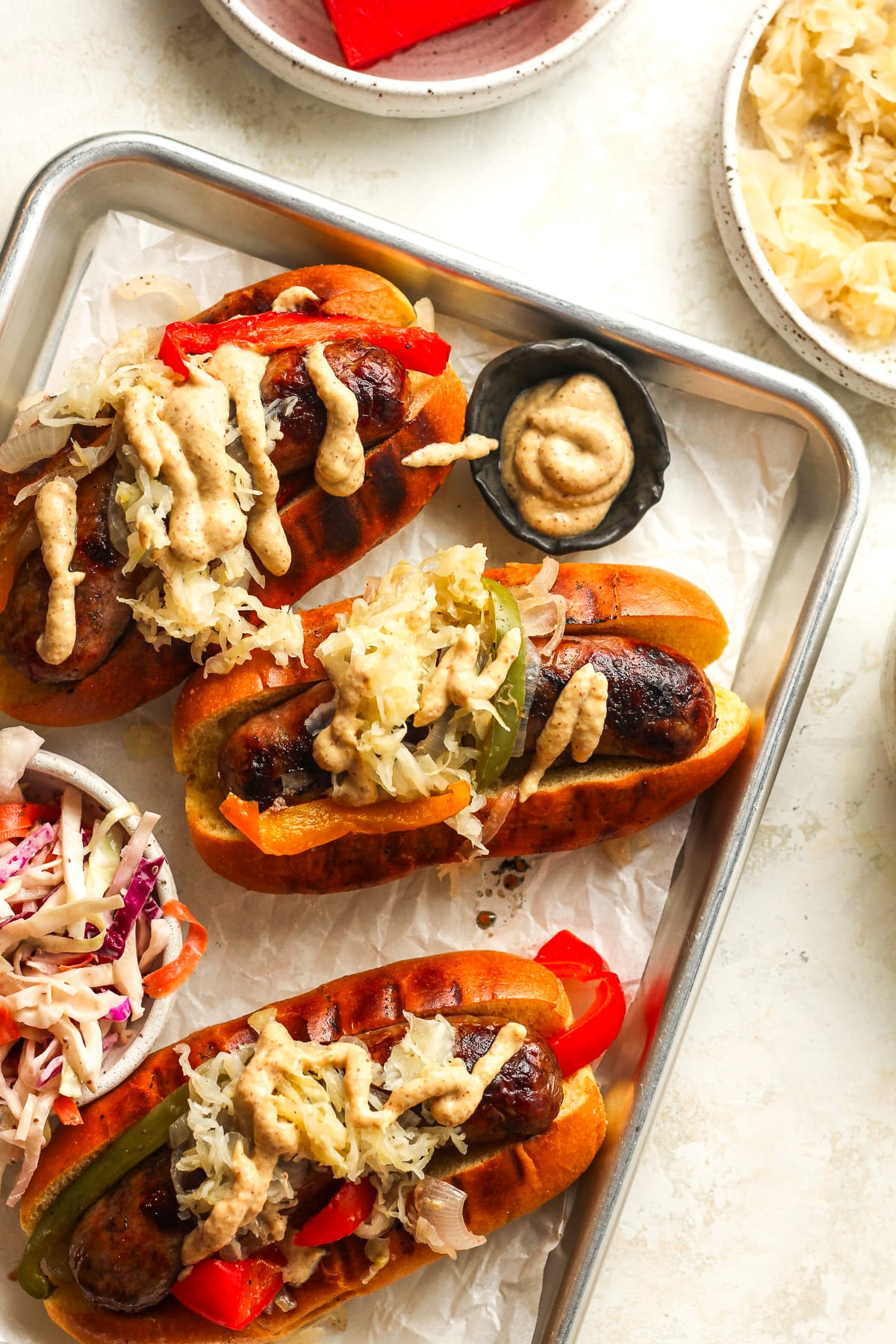 A tray of grilled beer brats in toasted buns.