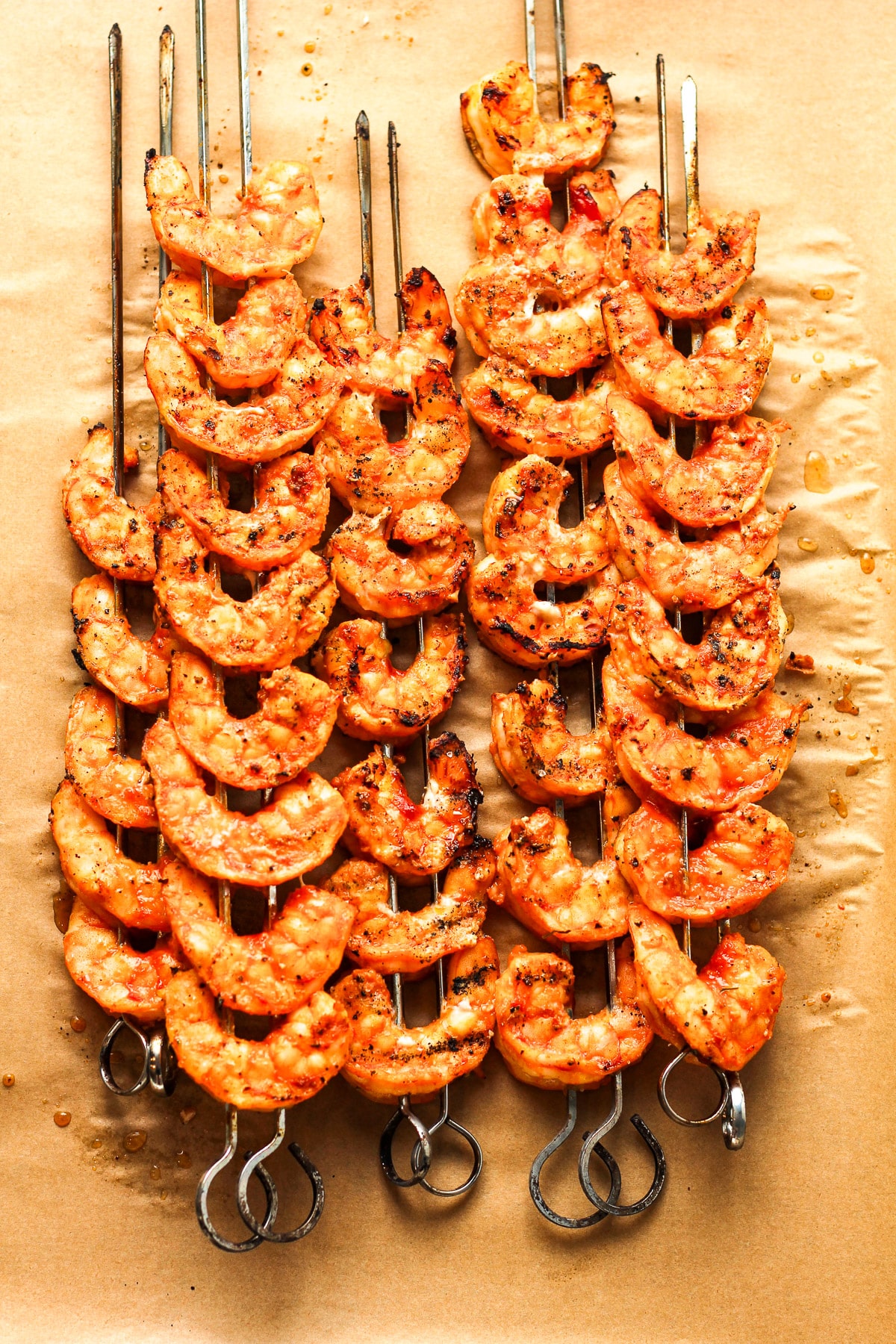 Some skewered grilled shrimp on a tray.