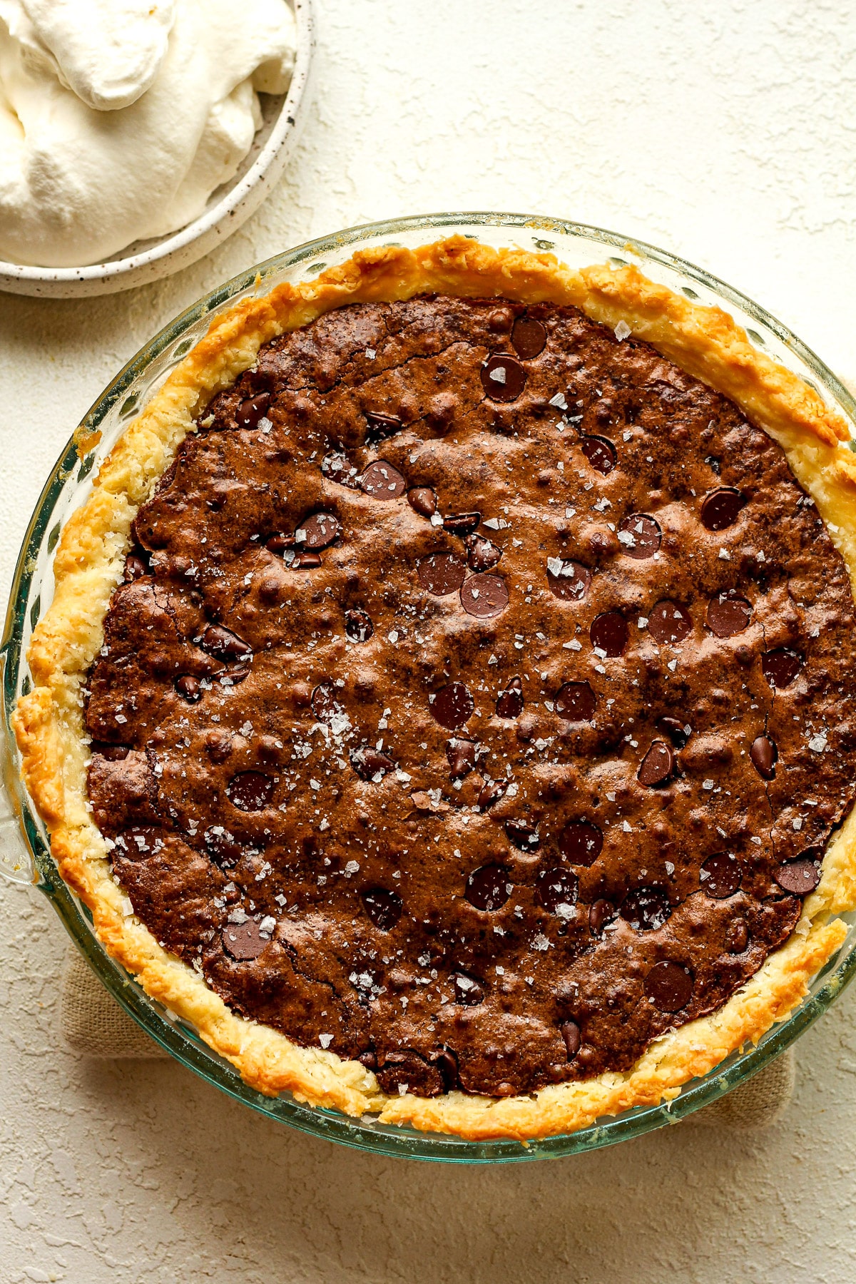 Overhead view of a triple chocolate brownie pie with sea salt on top.