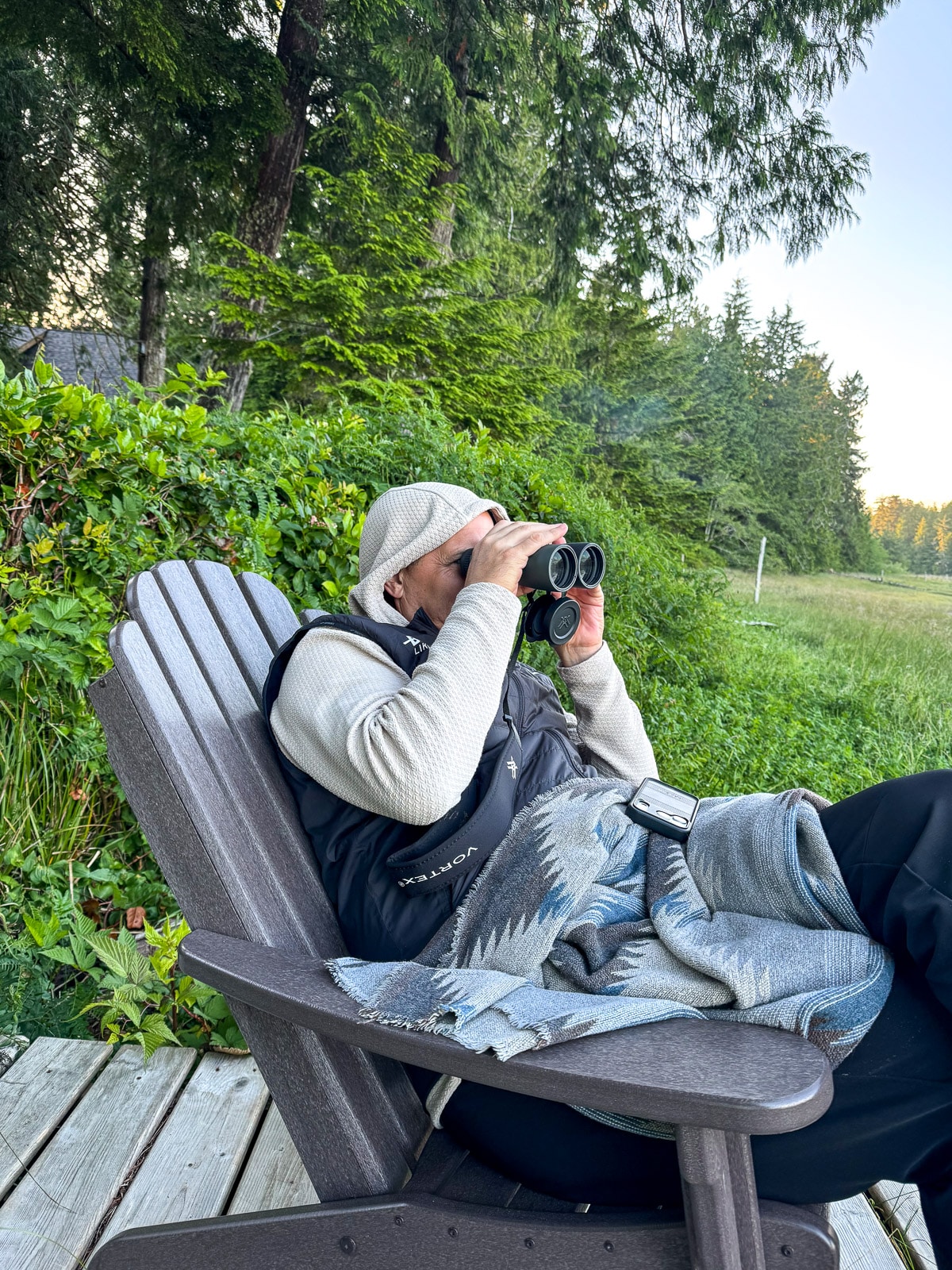 Mike bundled up looking through binoculars watching a bear.