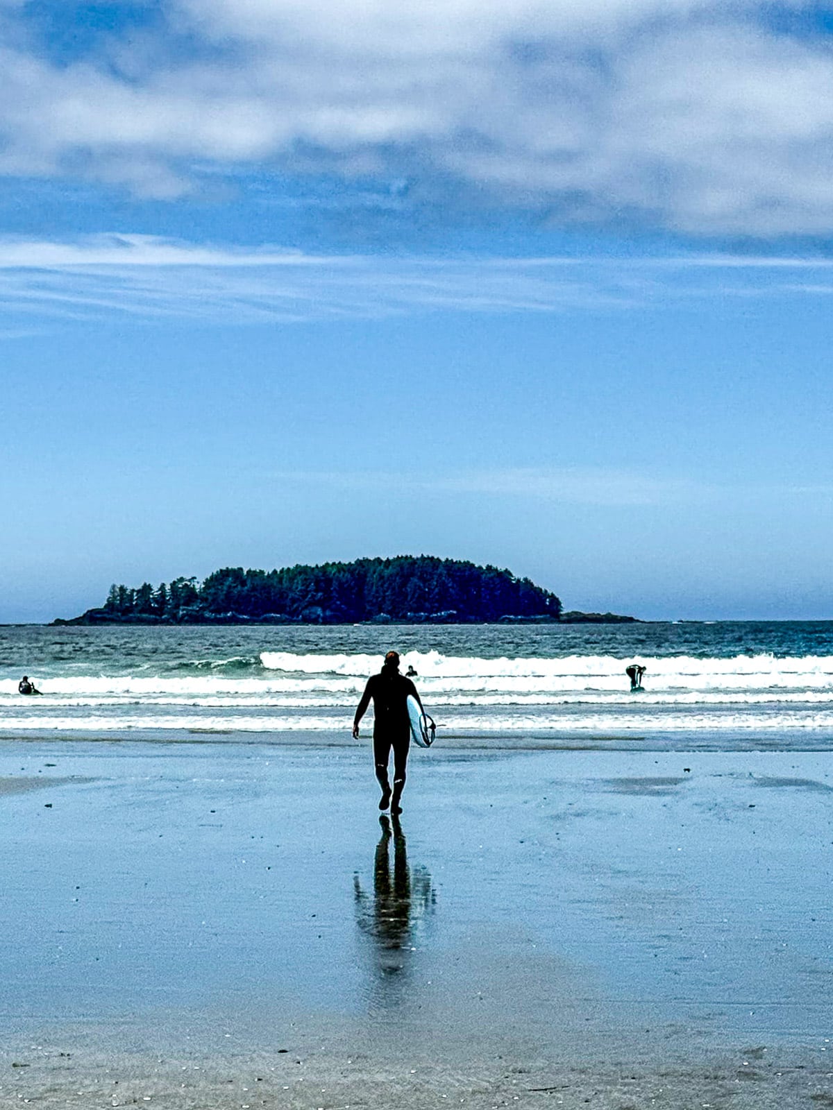Mike heading into surf with his surfboard.