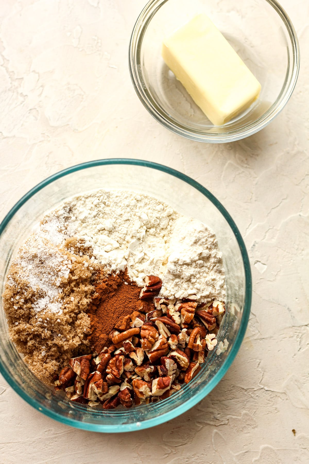 A bowl of the dry ingredients with a small bowl of butter.