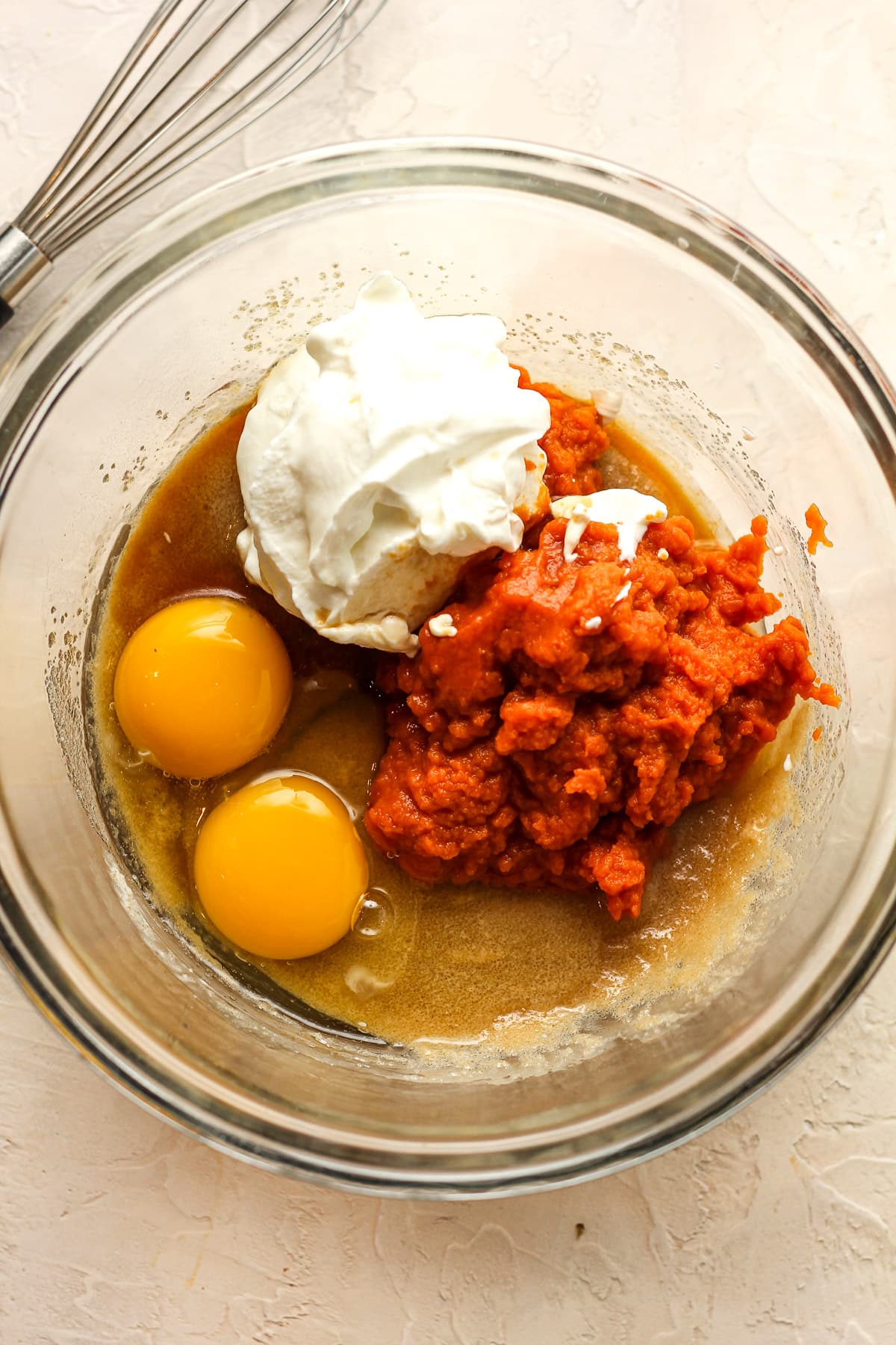 A bowl of the wet ingredients for pumpkin cake.