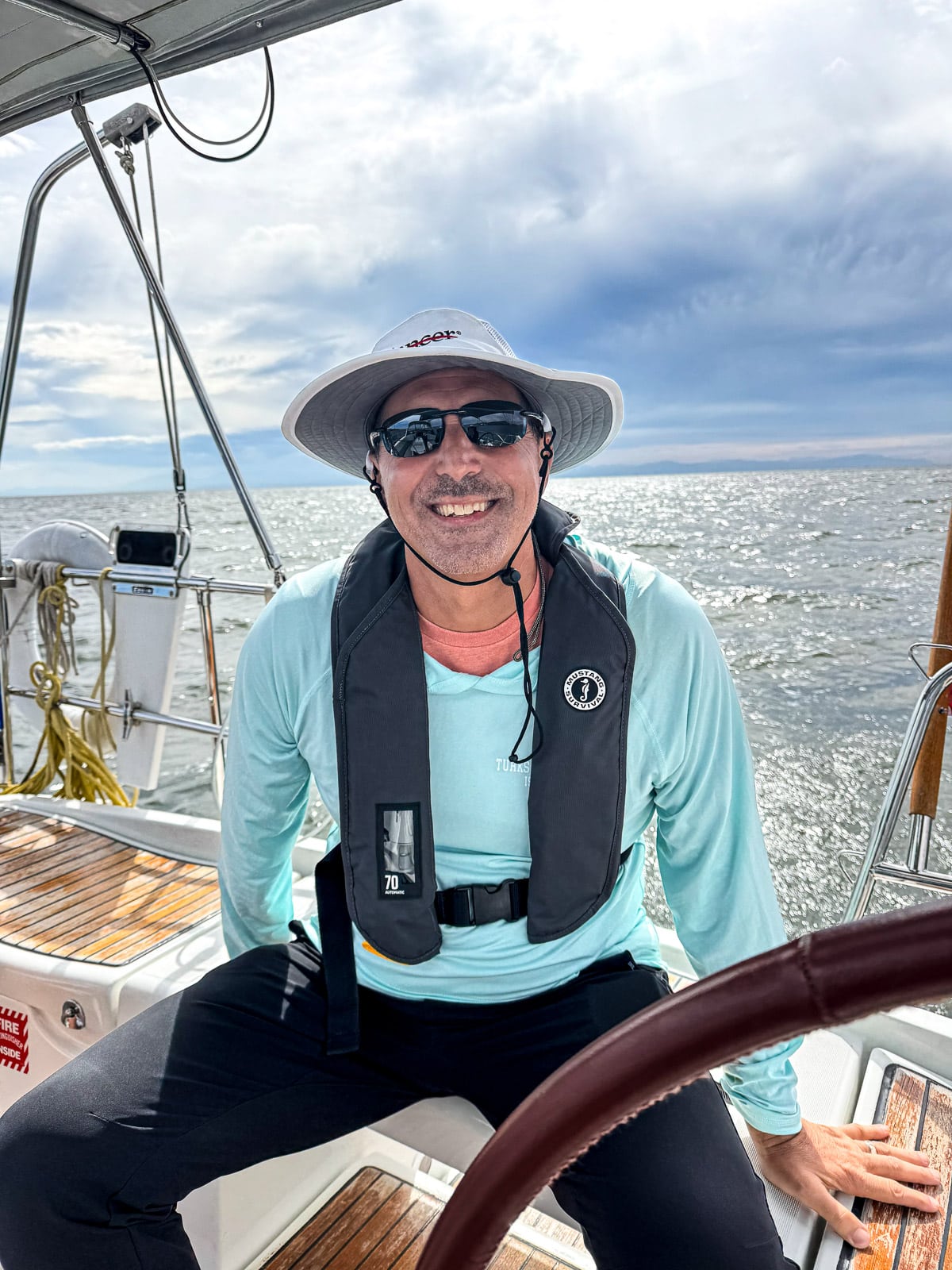 Mike sitting on the back of the sailboat.