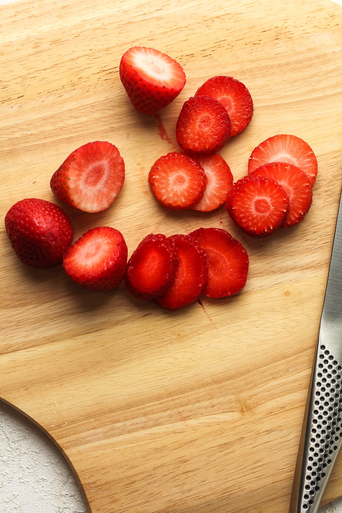 A board with sliced strawberries.