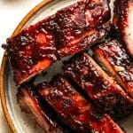 Closeup on a plate of smoked baby back ribs.