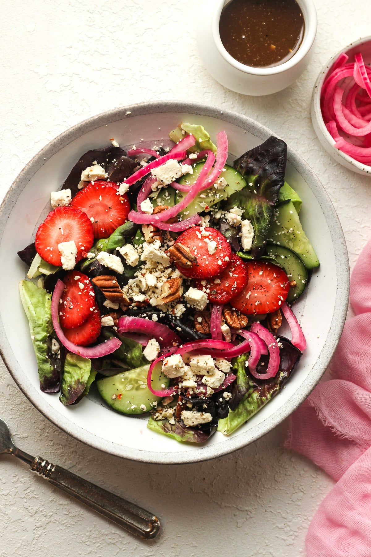 A serving of the strawberry green salad with strawberries and balsamic dressing.