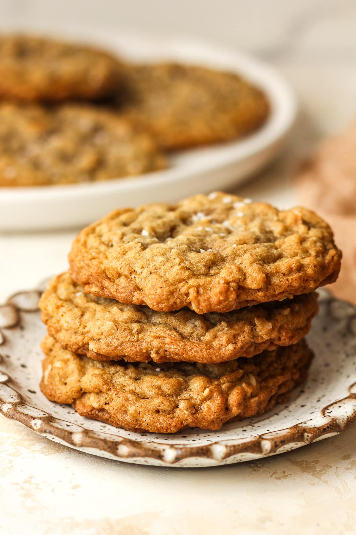 Side view of a stack of three cookies on a small plate.