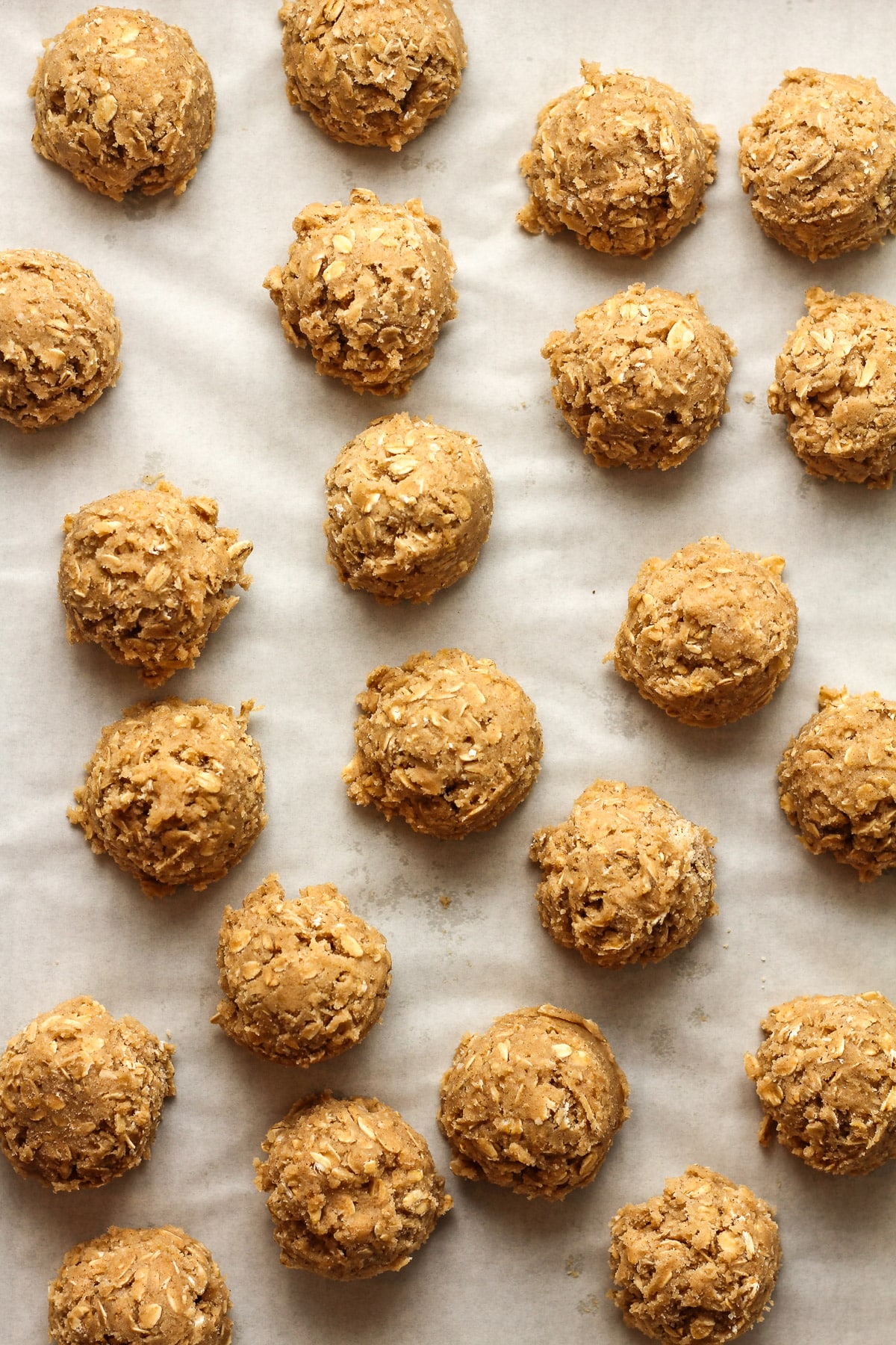 Overhead view of the cookie balls on a pan lined with parchment paper.