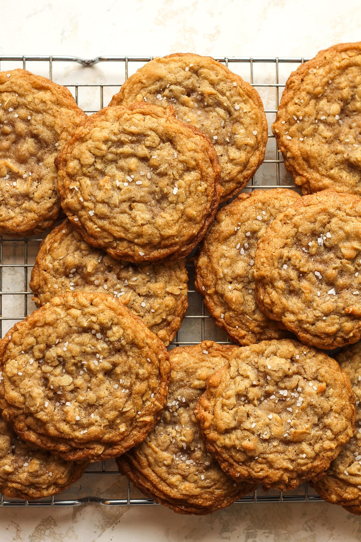 A wire rack with stacked oatmeal cookies.