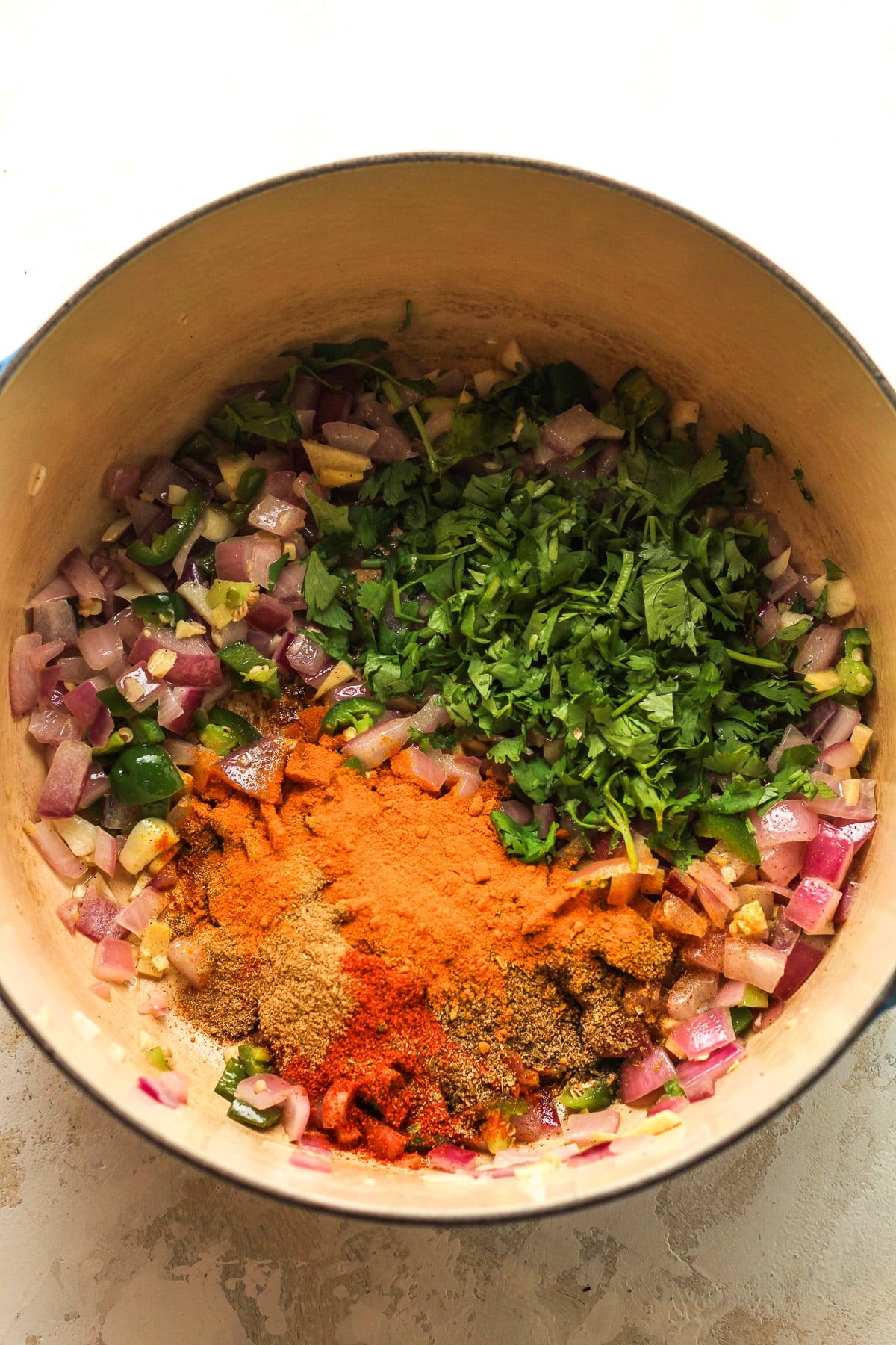 A pot of the sautéed veggies plus cilantro and seasonings on top.