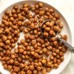 Closeup on a plate of crispy chickpeas with a tablespoon.