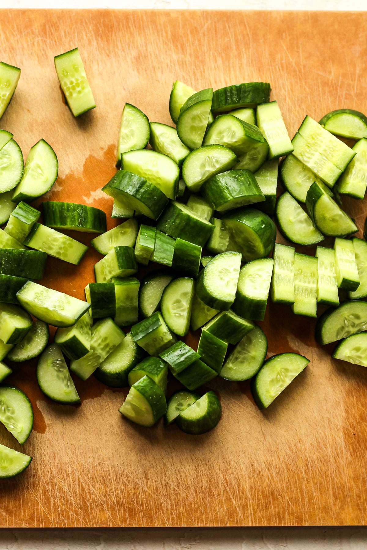 A board with the chopped cucumber.