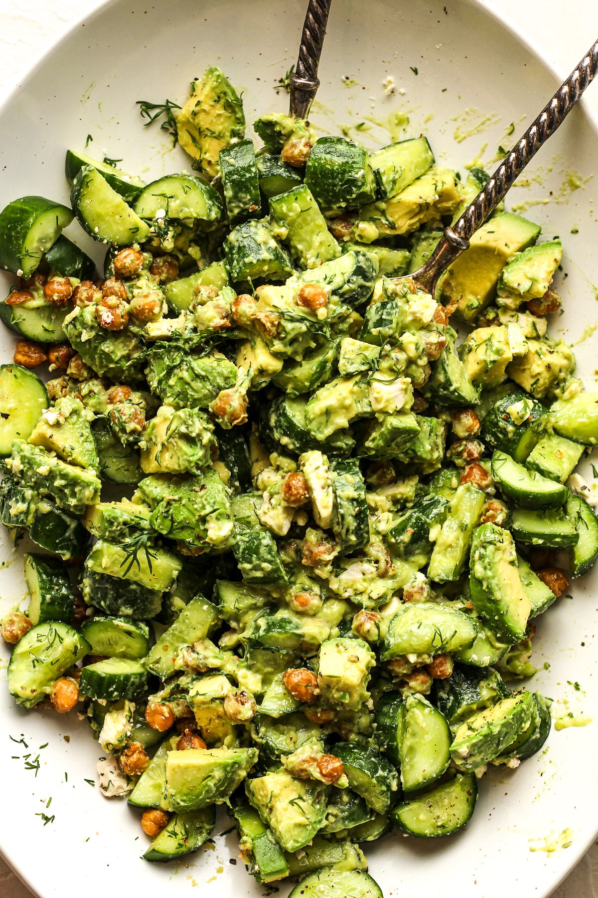 Closeup on the cucumber avocado salad after mixing in the dressing.