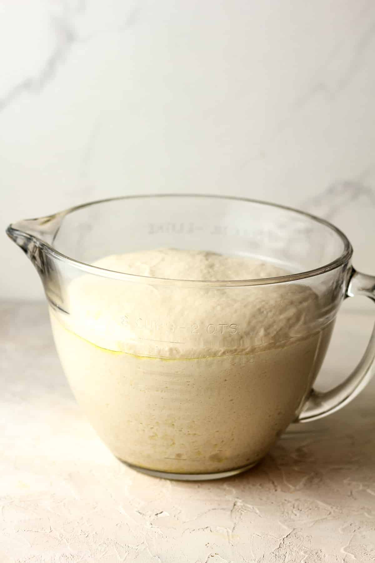 Side view of a large measuring cup of the pretzel dough.