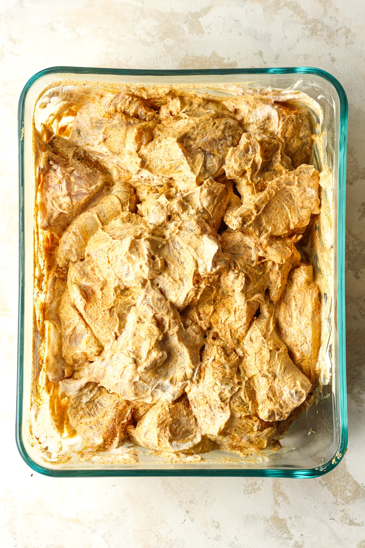 A rectangular dish of the marinated chicken.