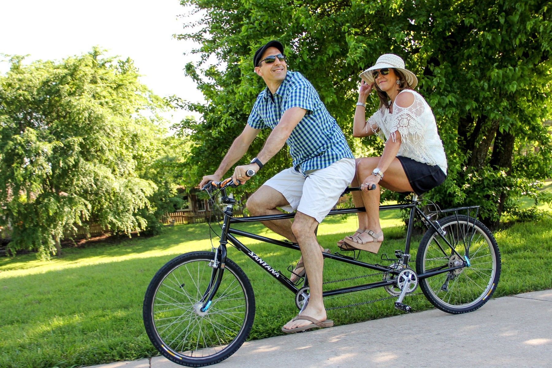 Mike and I on a tandem bike riding through the park - me with my legs off the pedals while Mike steers.