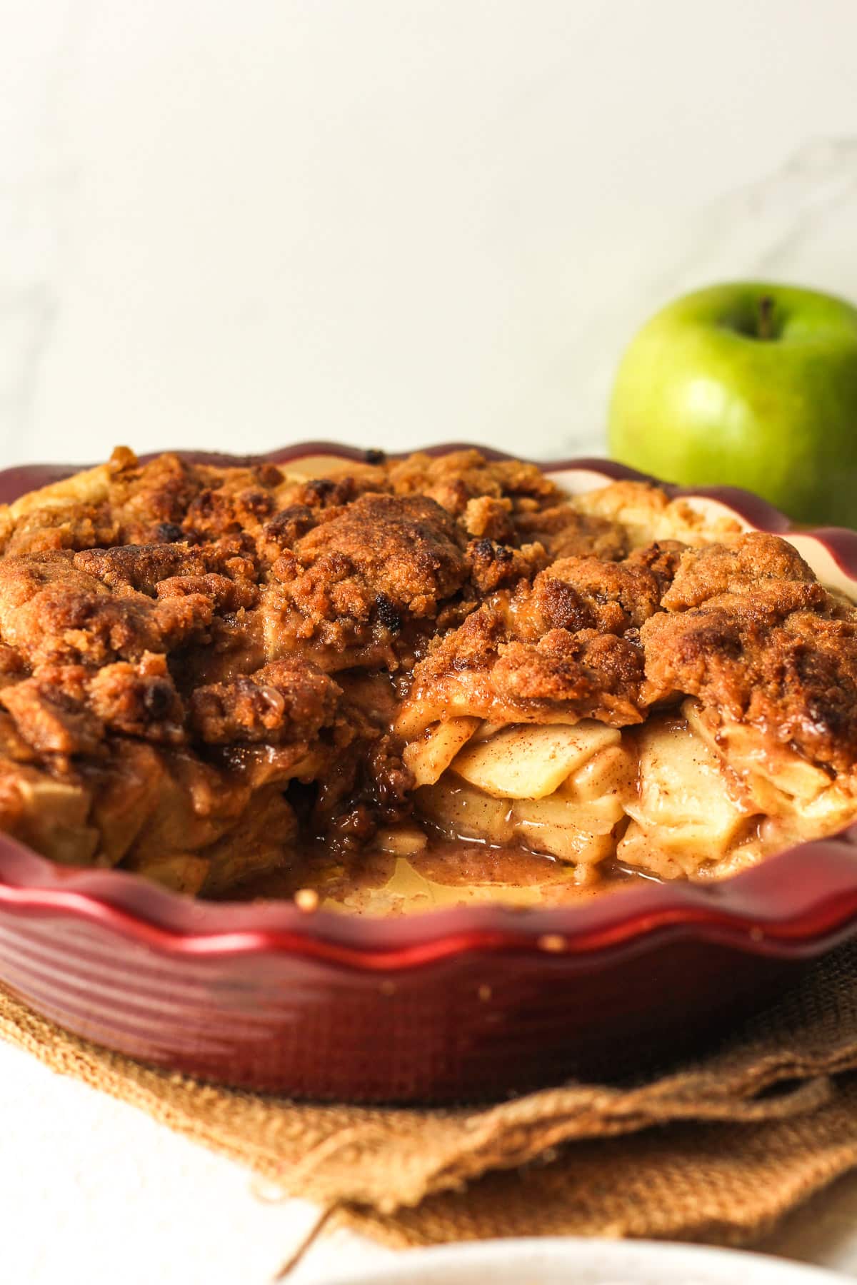 Side view of an apple crumble pie showing the insides.