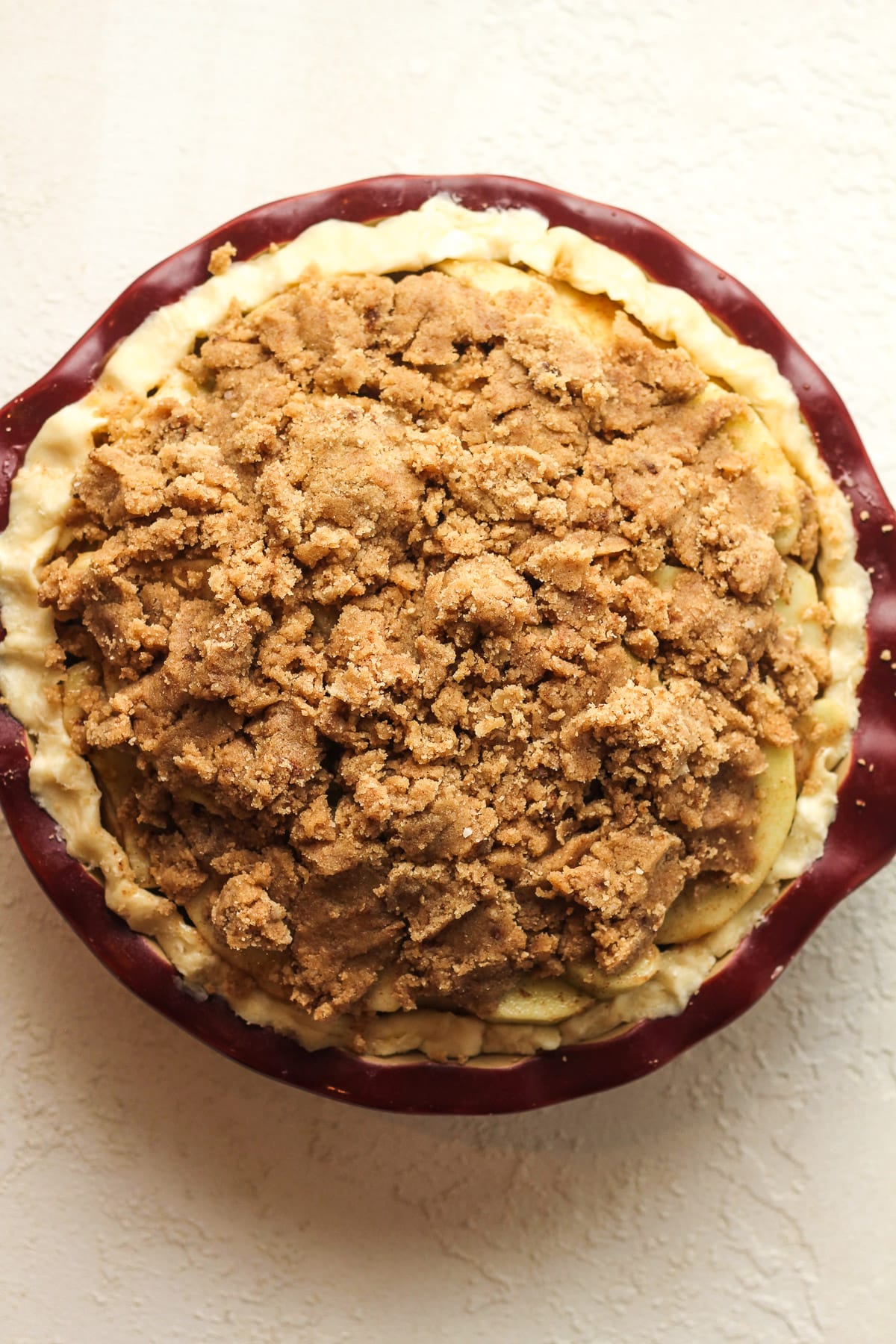 Overhead view of a burgundy pie plate before baking it.