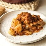 Side view of a slice of apple crumble pie.