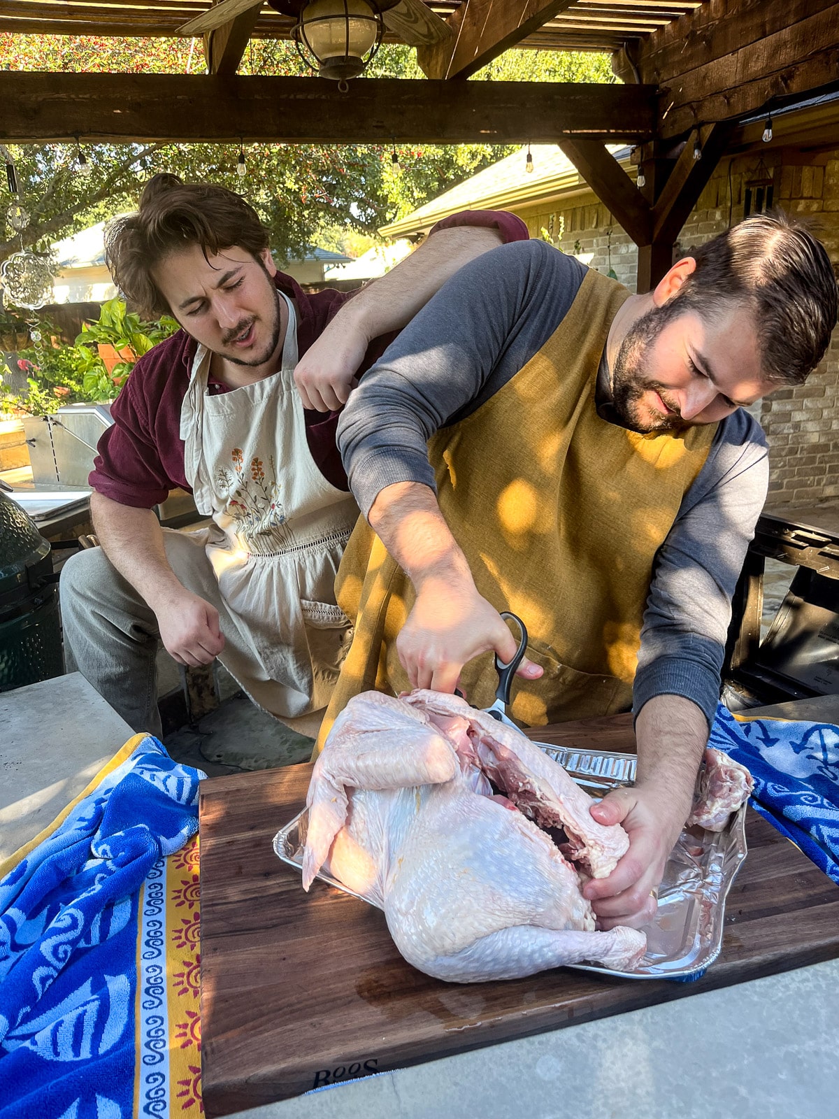 Josh and Zach on the deck spatchcocking a large turkey.