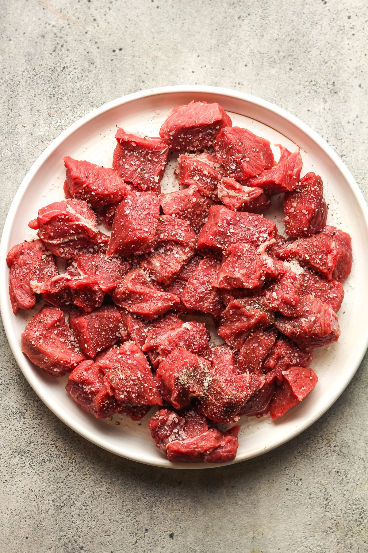 A plate of the small steak bites with salt and pepper.