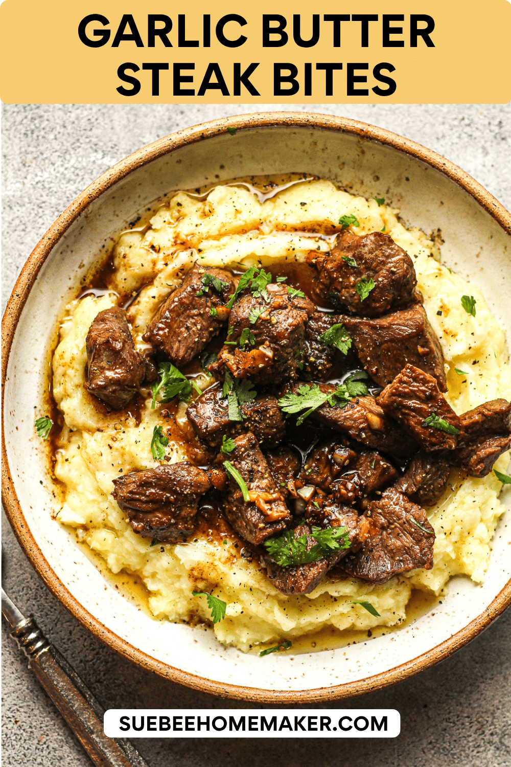 A bowl of garlic butter steak bites over cauliflower potato mash.