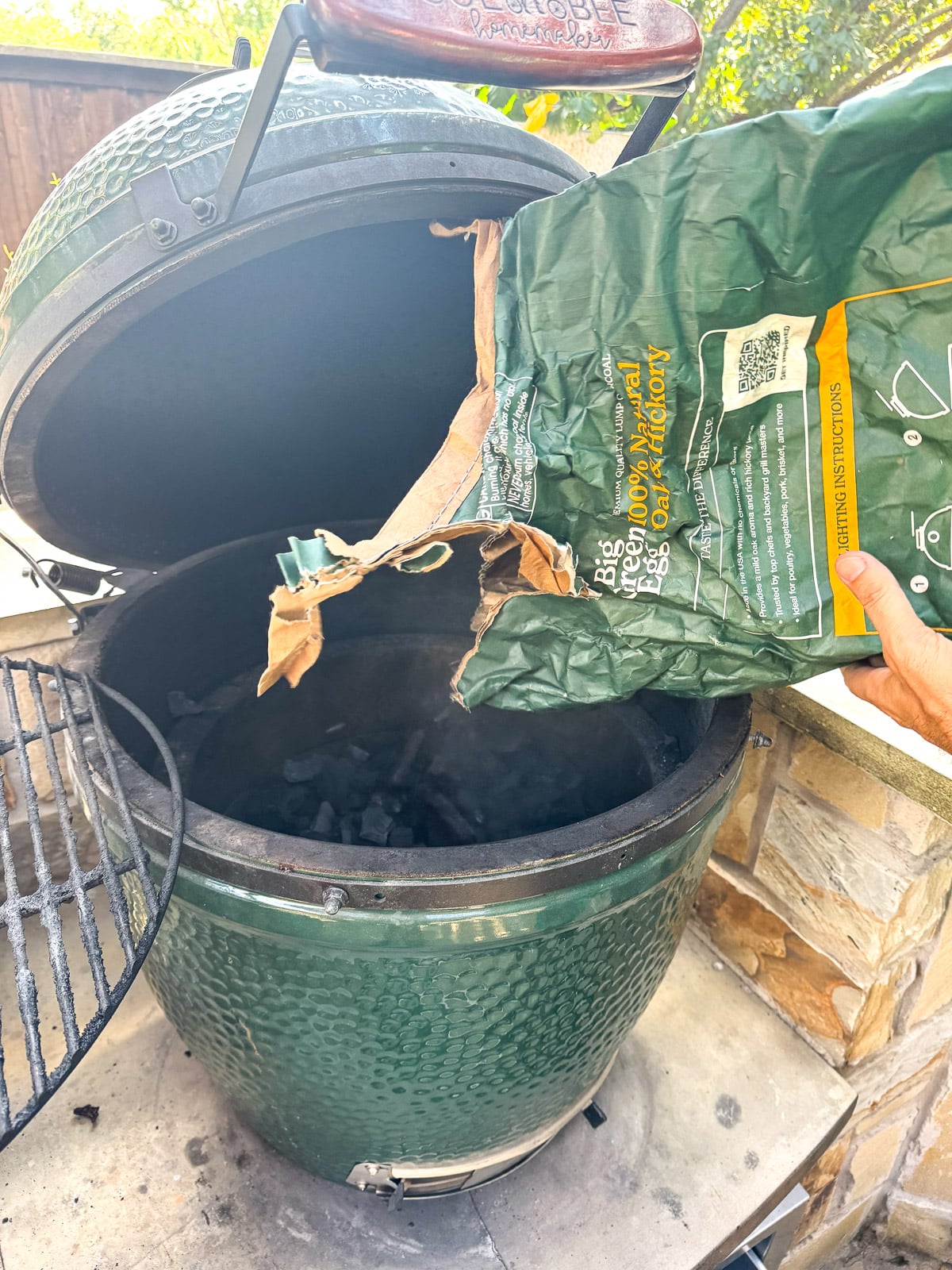 The charcoal being poured into a Big Green Egg.