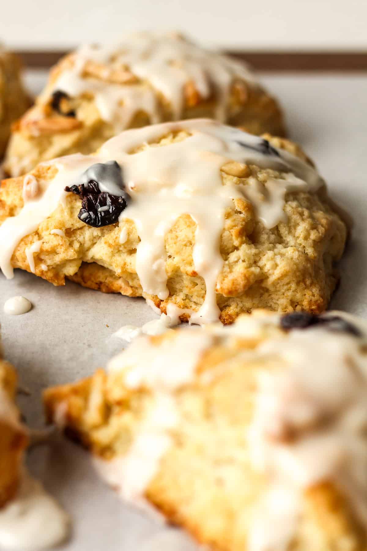 Side view of some iced cherry almond scones.