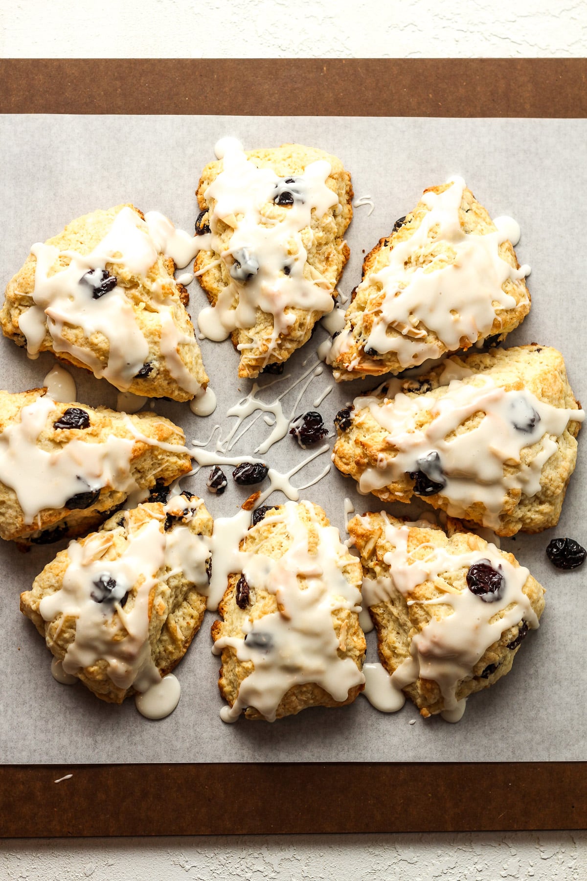 Overhead view of triangular cherry almond scones with icing.