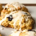 Side view of some iced cherry almond scones.