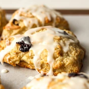 Side view of some iced cherry almond scones.