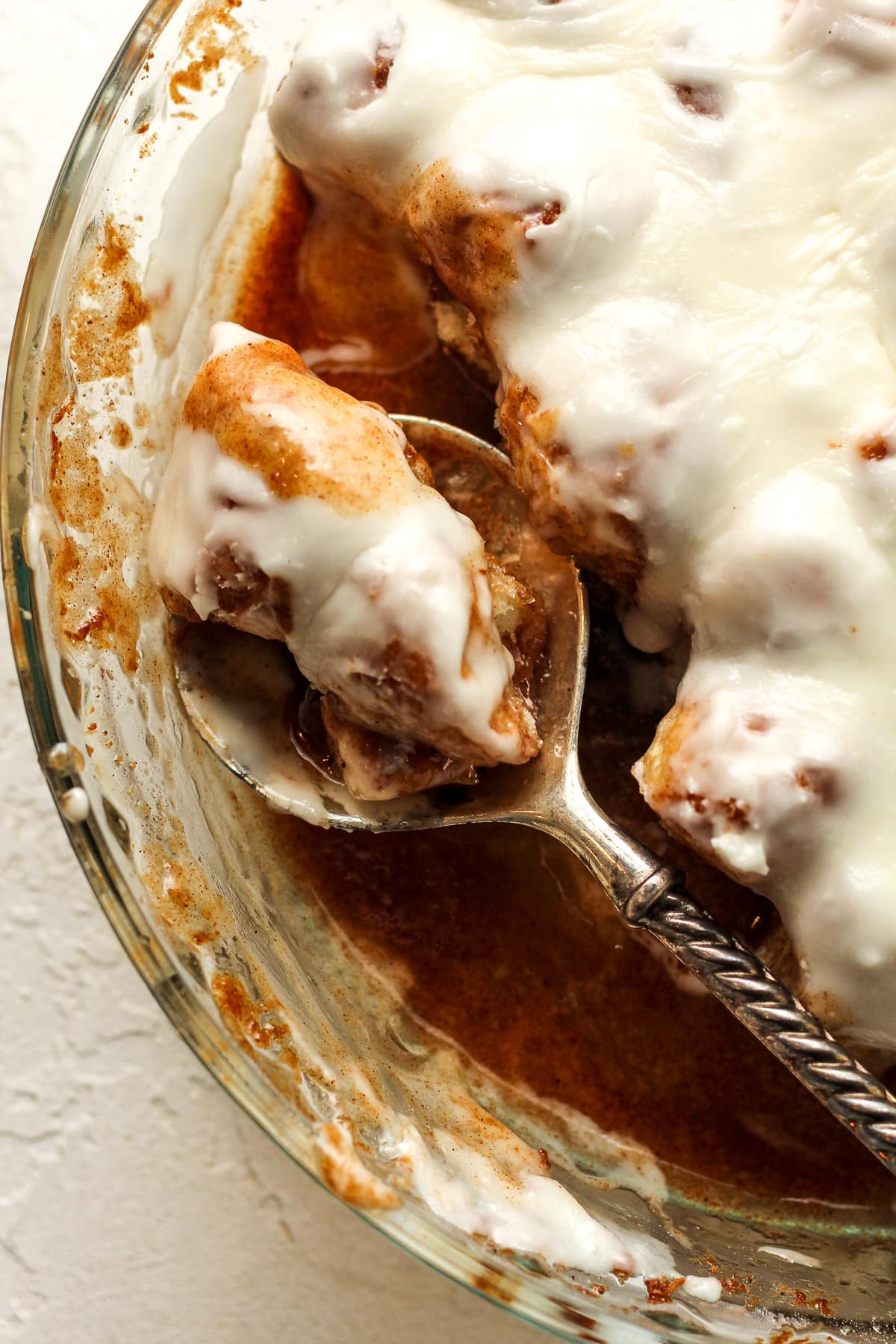 Closeup on the cinnamon roll bites dish with a two bites on a spoon.
