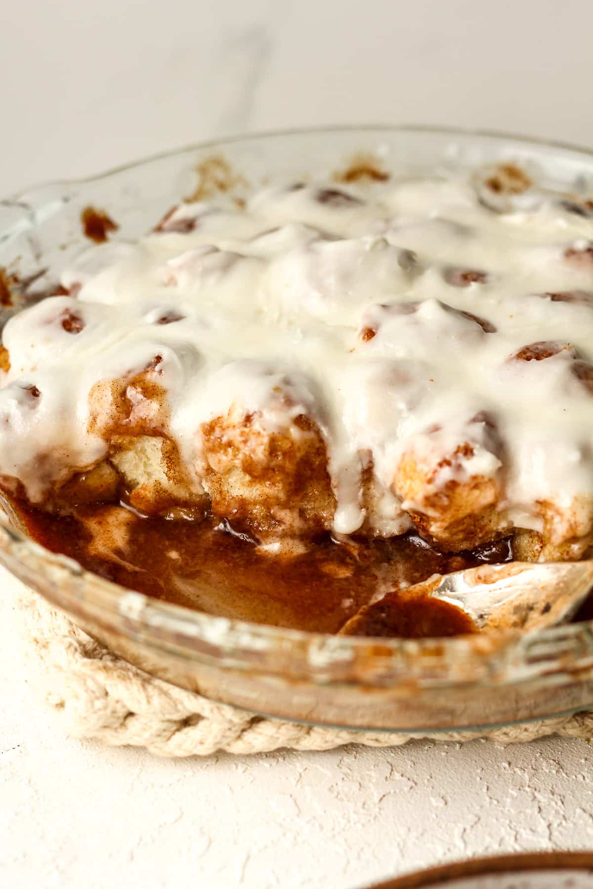 Side view of the dish of cinnamon roll bites with a spoon.