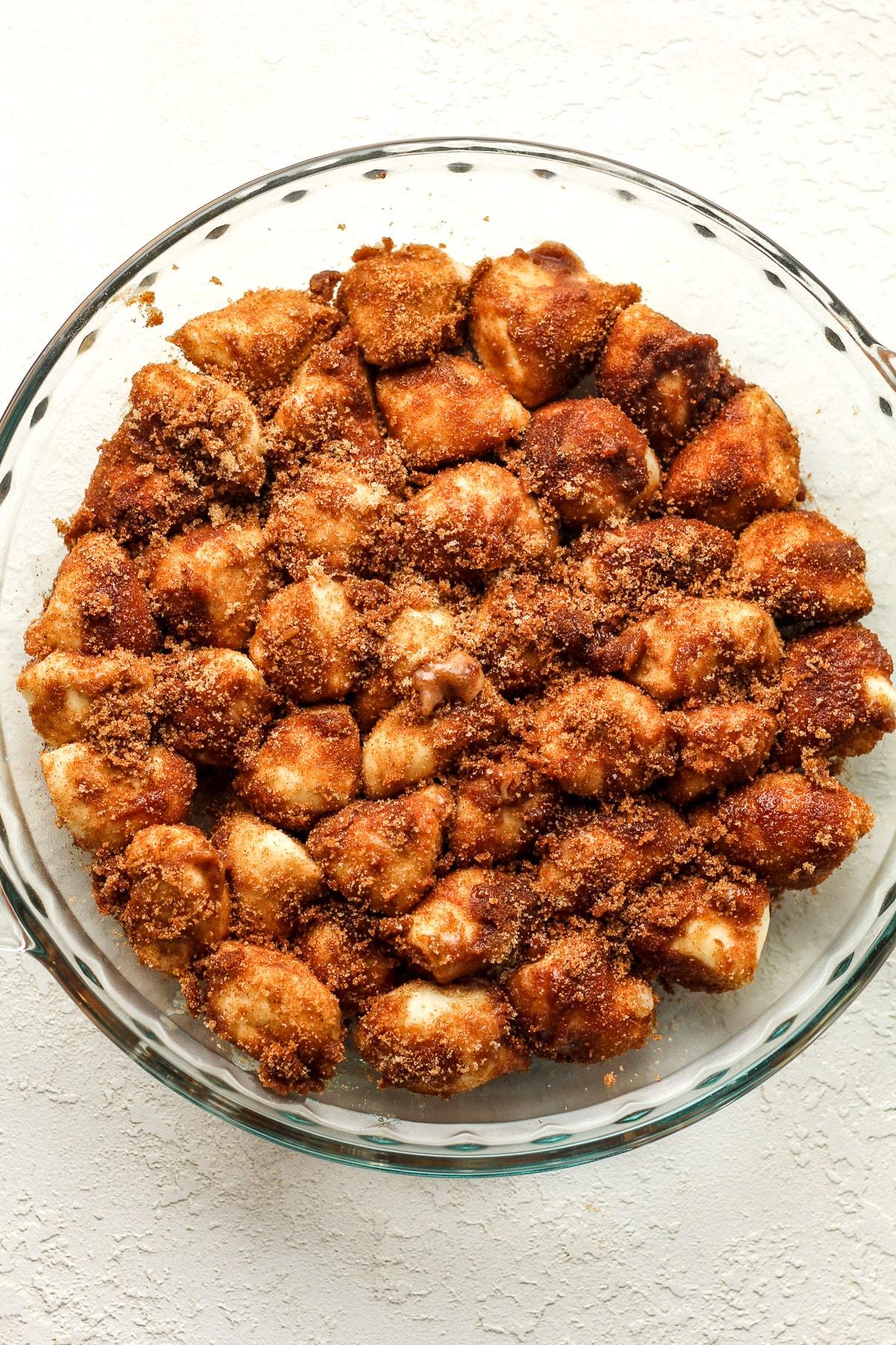 The cinnamon roll dough bites in a glass pie dish.