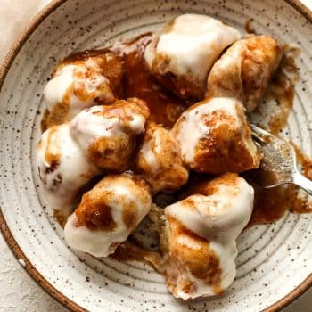 Closeup on a bowl of the cinnamon roll bites with a fork.