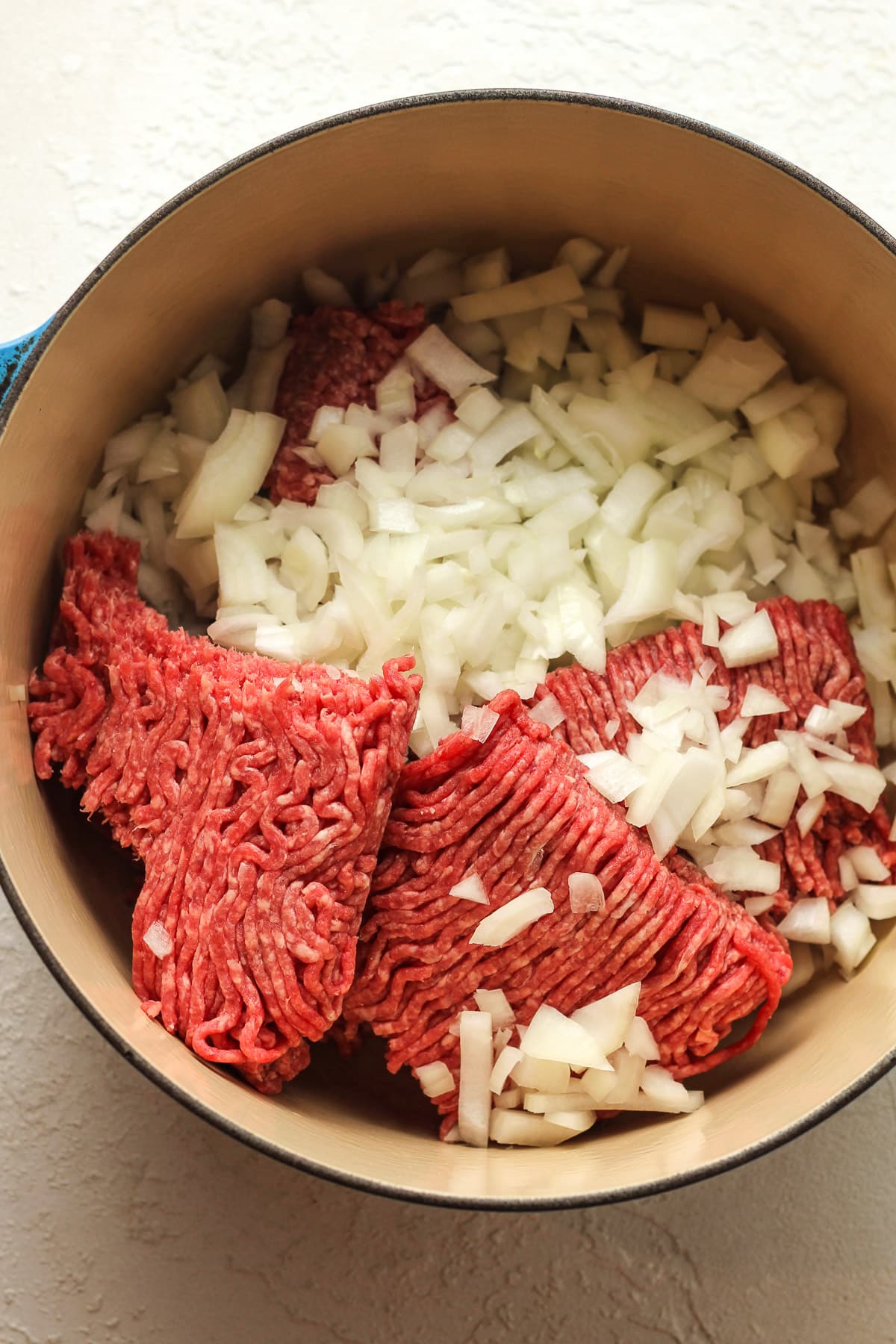 A pot of the ground beef and chopped onions.