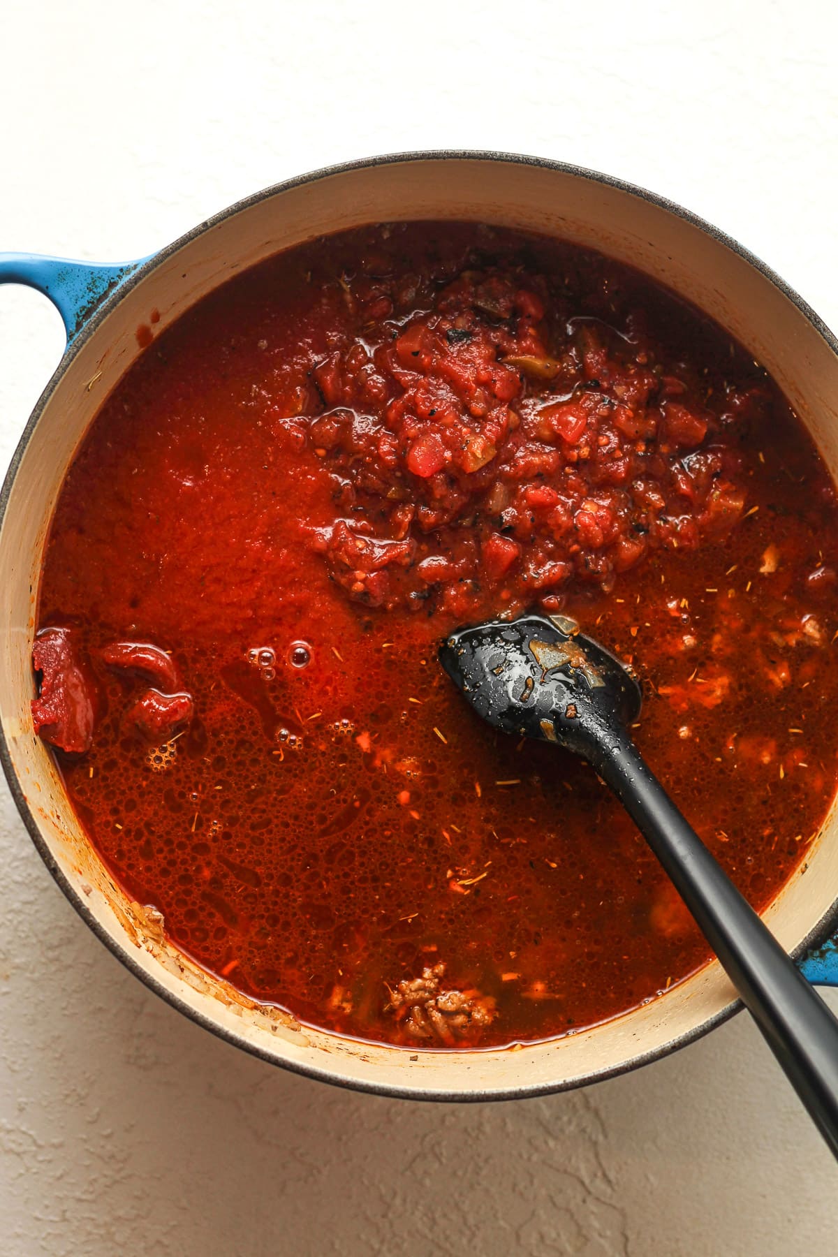 A pot of the browned meat and the tomatos and broth stirred in.