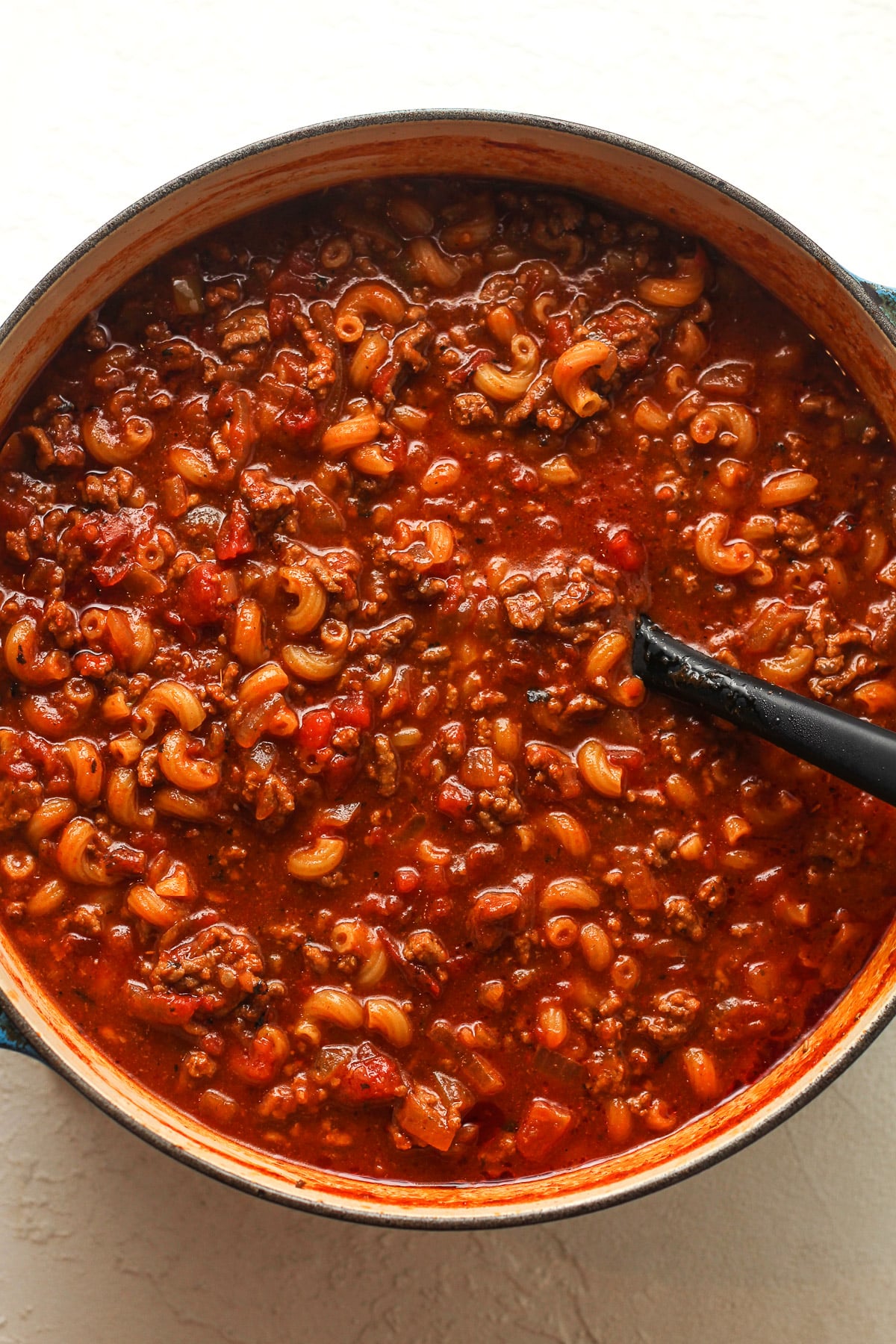 A large pot of goulash with a silicone spatula.
