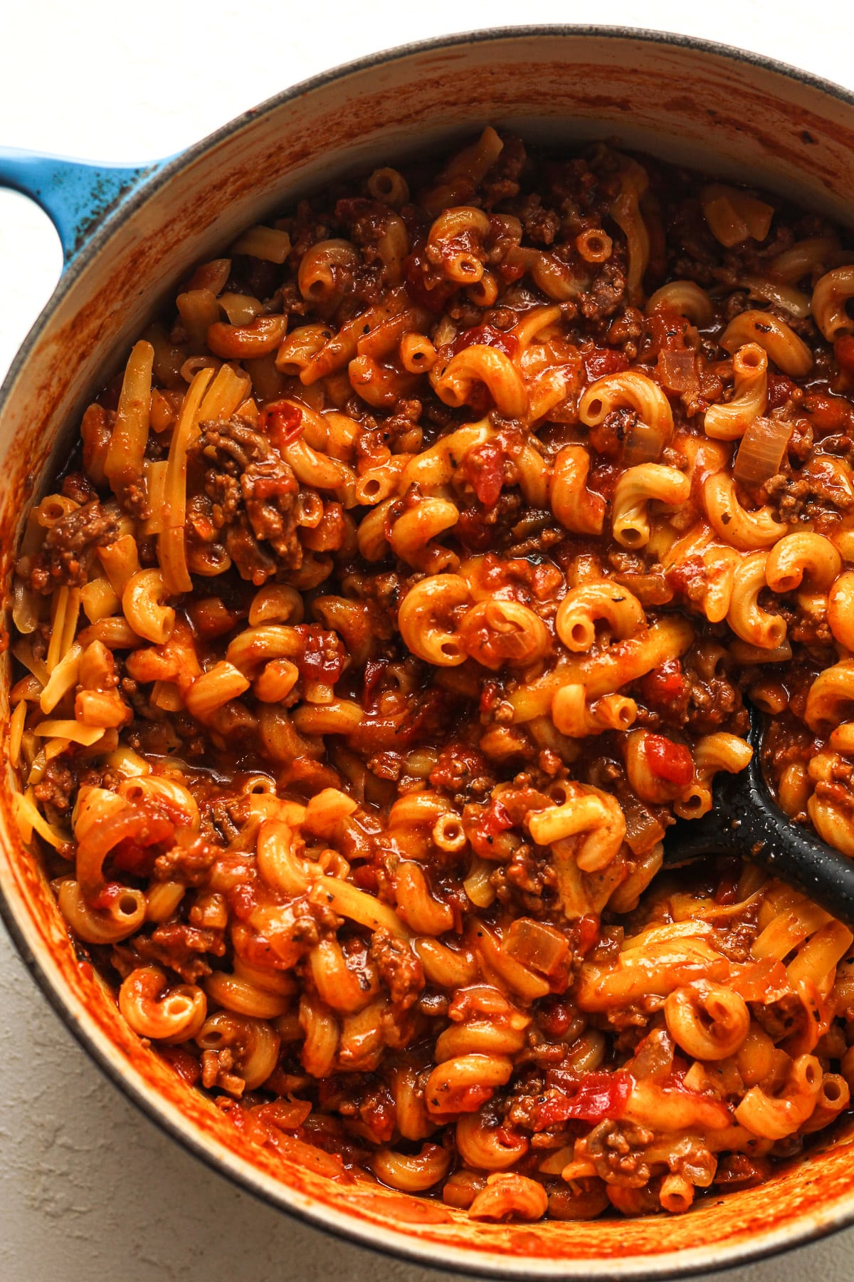 Closeup on a large pot of goulash with cheese.